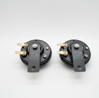 Two black mechanical components on a wooden surface