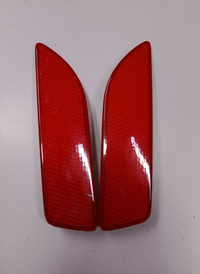 Two red car taillights with a textured surface on a white background