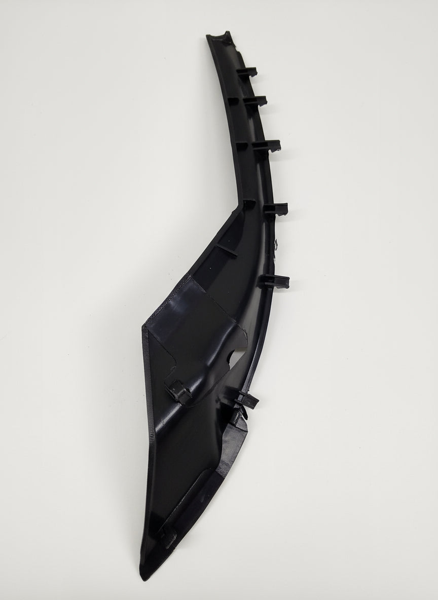 Black plastic car part on a tiled floor