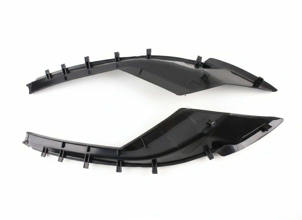 Two black plastic car parts on a tiled floor