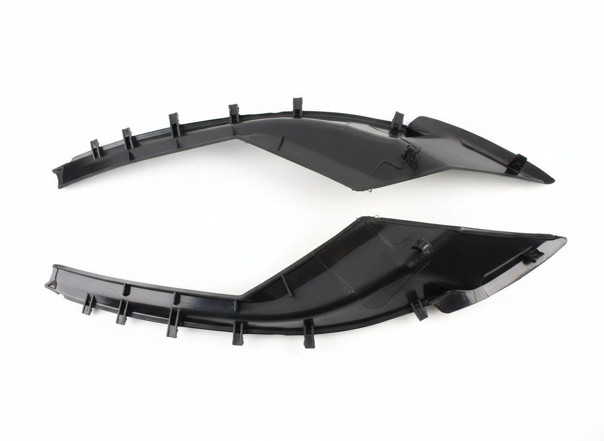 Two black plastic car parts on a tiled floor