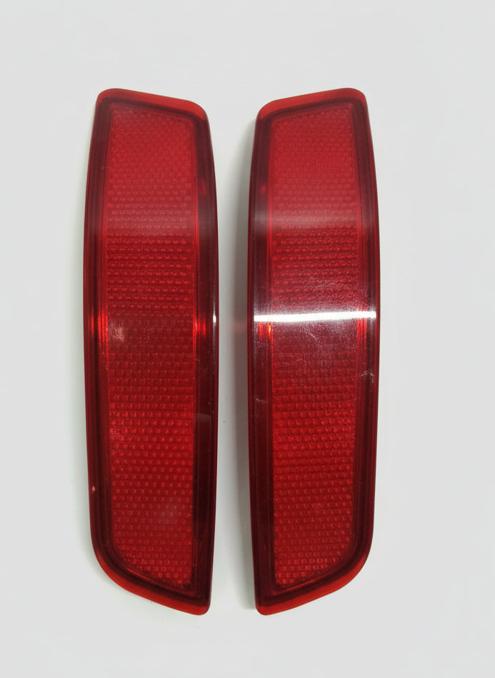 Two red car taillights on a white background
