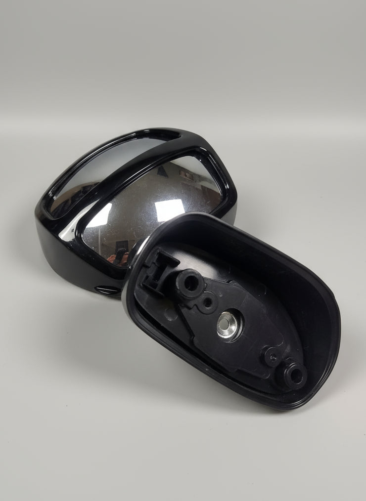 Black motorcycle mirror on a pink surface with a blurred background