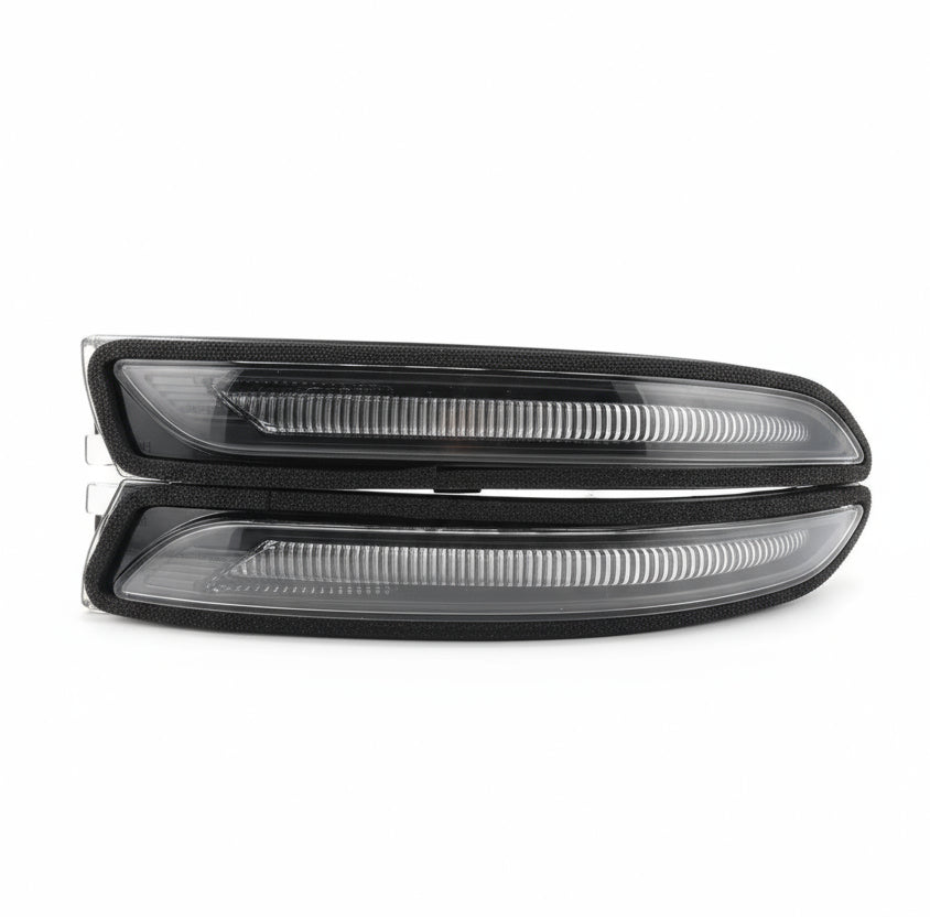 Two black car headlights in packaging on a wooden surface