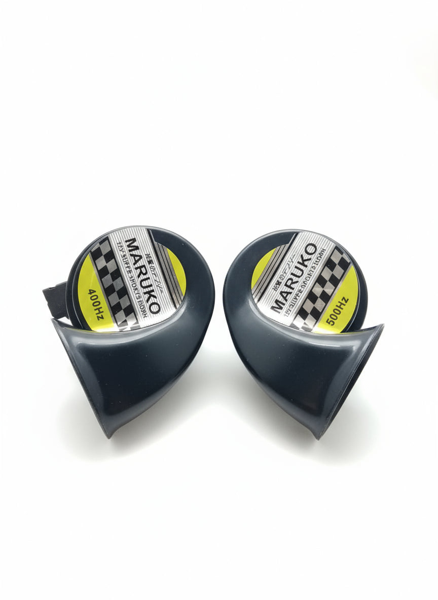 Two black MARUKO horns on a wooden surface with a box in the background.
