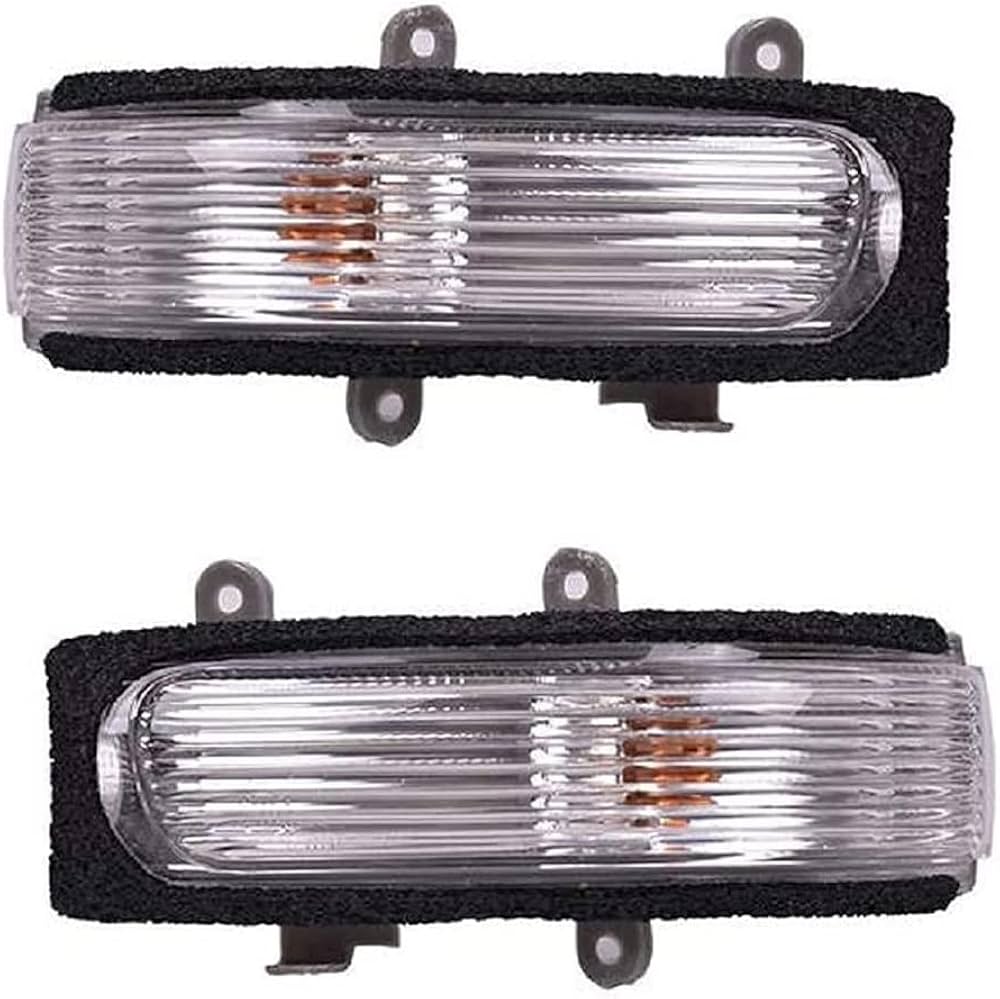 Two clear automotive fog lights with black protective covers on a white background