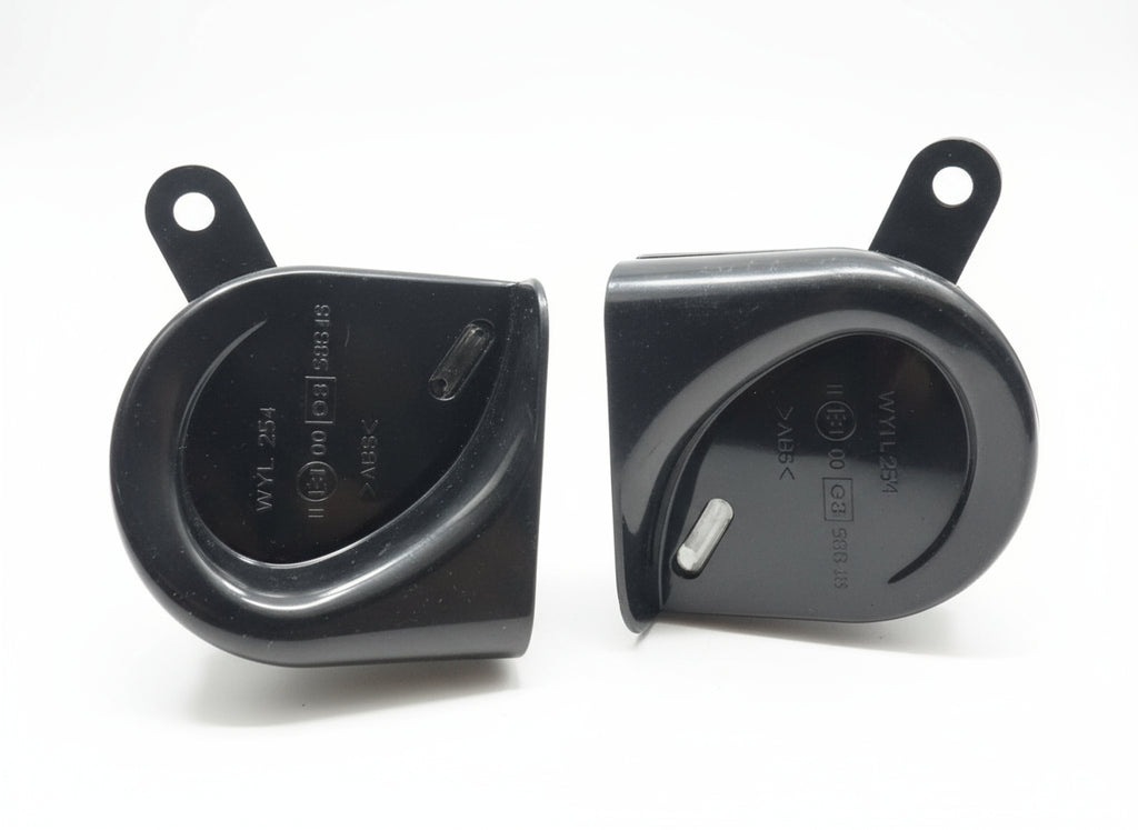 Two black plastic components on a wooden surface