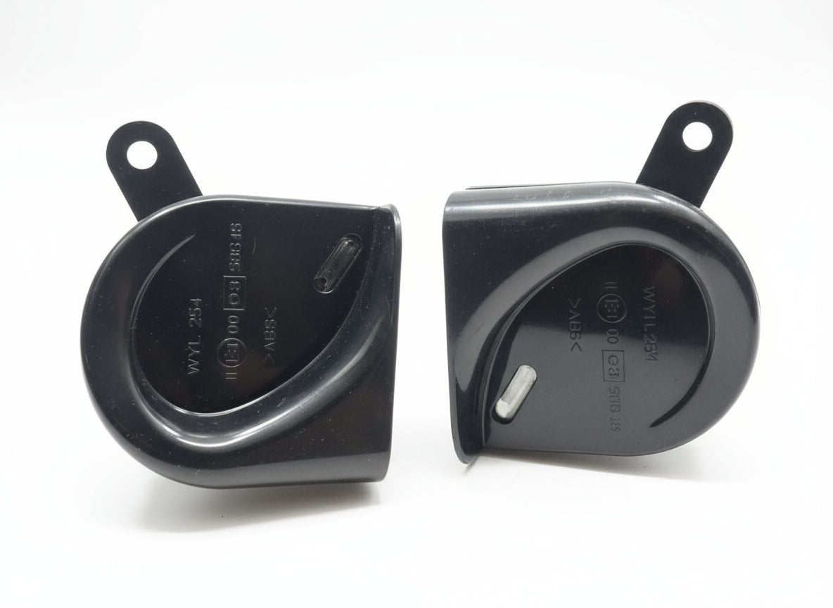 Two black plastic components on a wooden surface