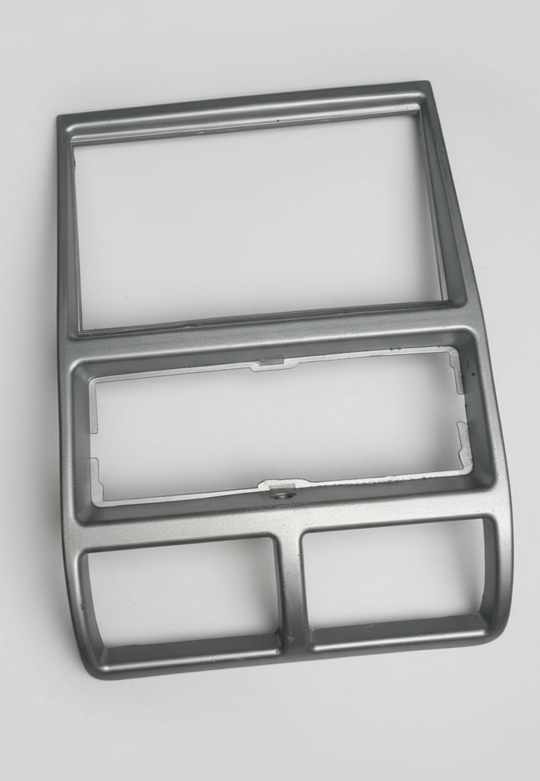 Metallic car dashboard panel with cutouts on a gray background