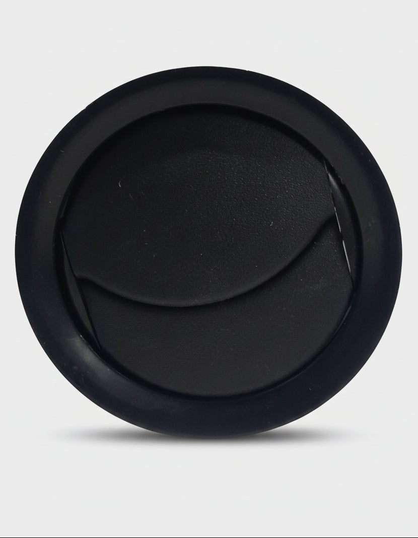 Black circular object on a textured gray background