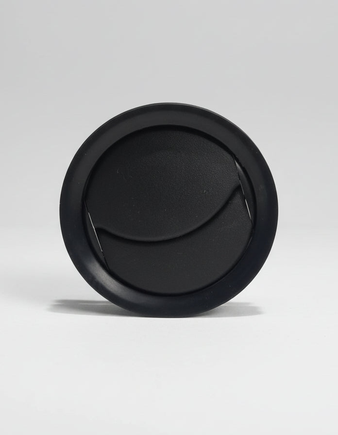 Black circular object on a textured gray background