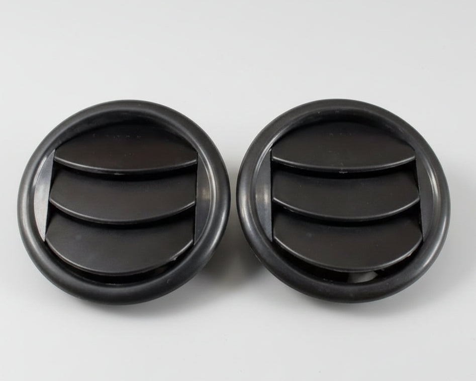Two black circular rubber grommets on a white background