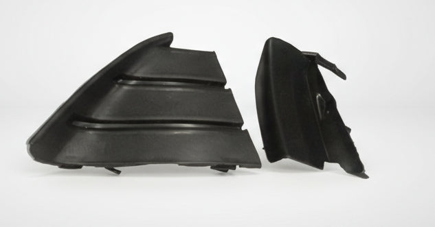Two black plastic car parts on a white background