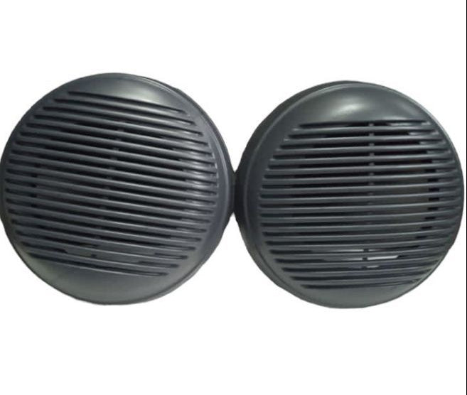 Two black round speakers with grill patterns on a white background