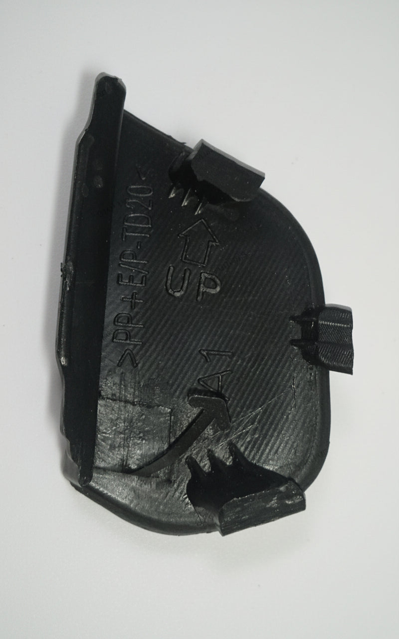 Black plastic component with text on a light gray background