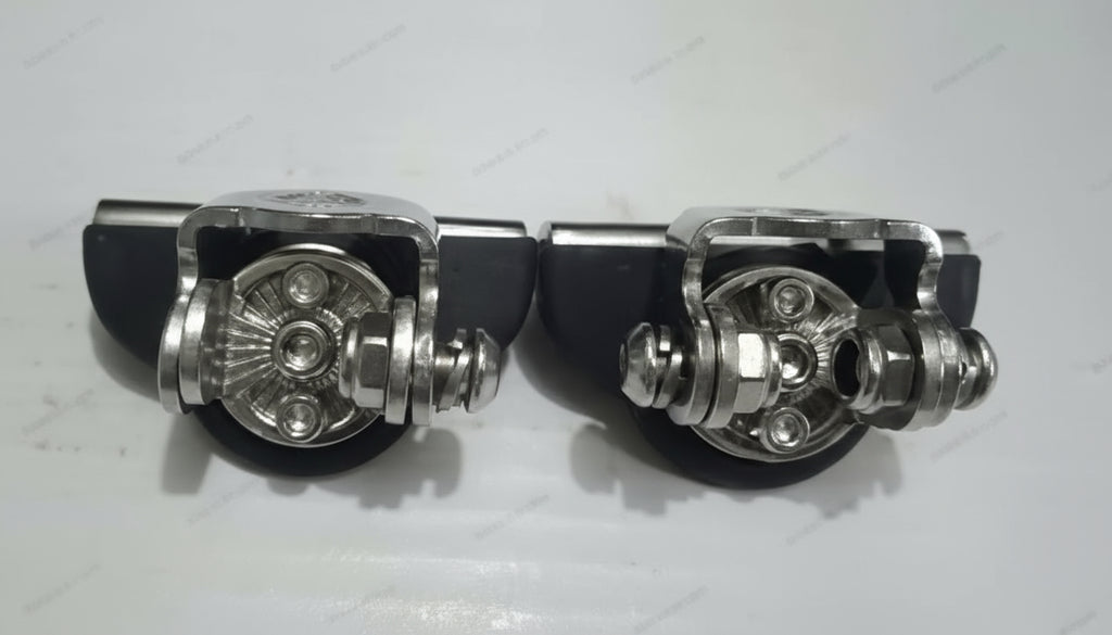 Two metallic pedal parts on a light gray background