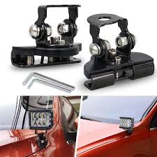 Two car roof racks with a tool and LED lights on a red car.