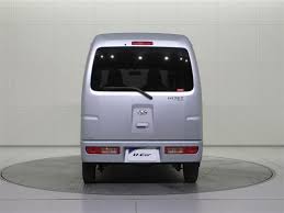 Back view of a white van on a gray platform with a white background