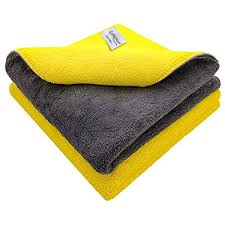 Gray and yellow folded towel with a brand label on a white background
