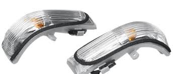 Two car fog lights with clear covers on a white background
