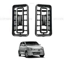 Two black car fog light covers with a silver car in the background