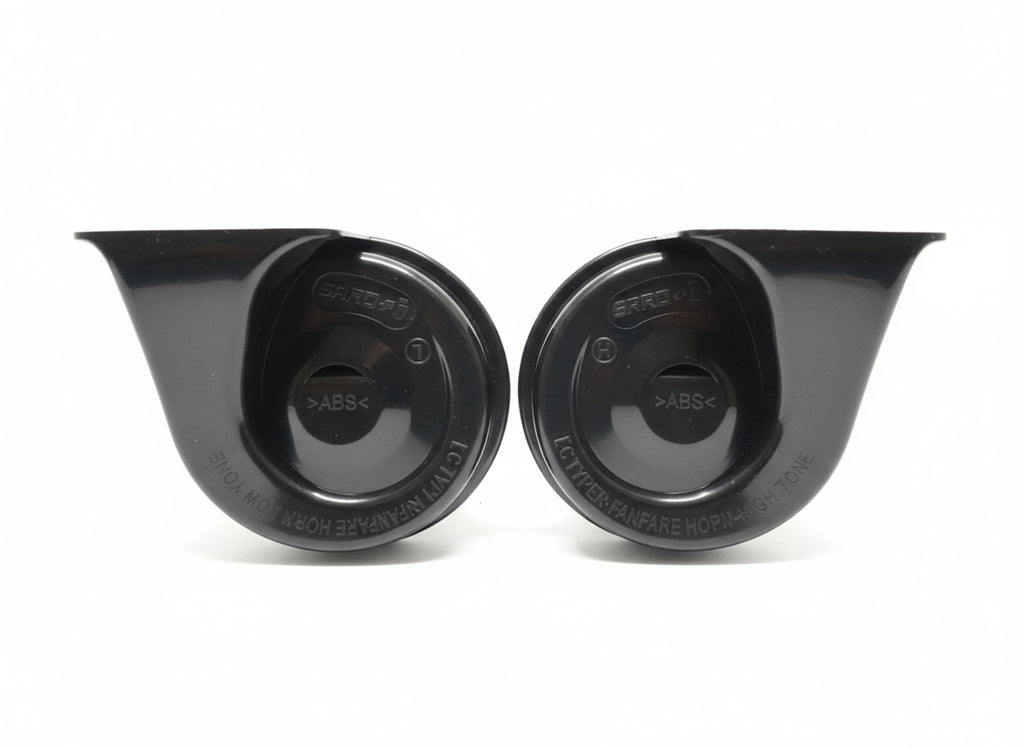 Two black plastic components on a wooden surface