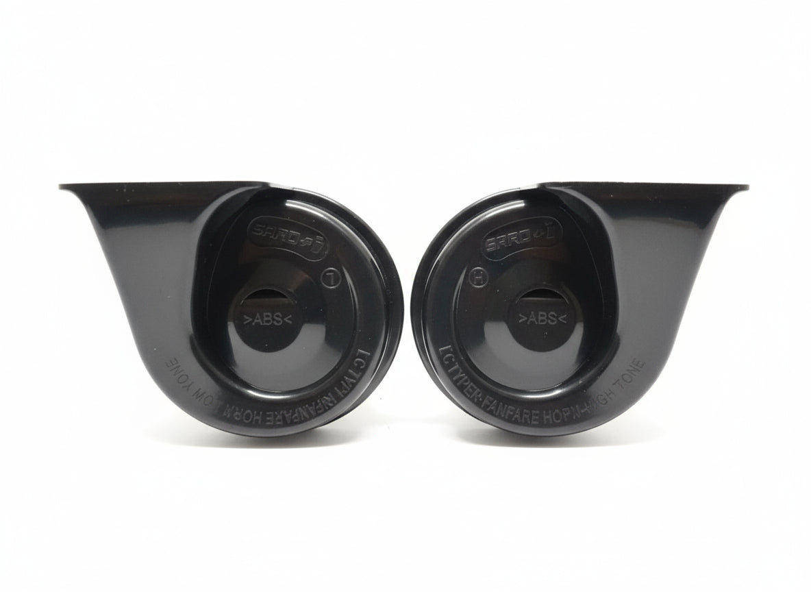 Two black plastic components on a wooden surface