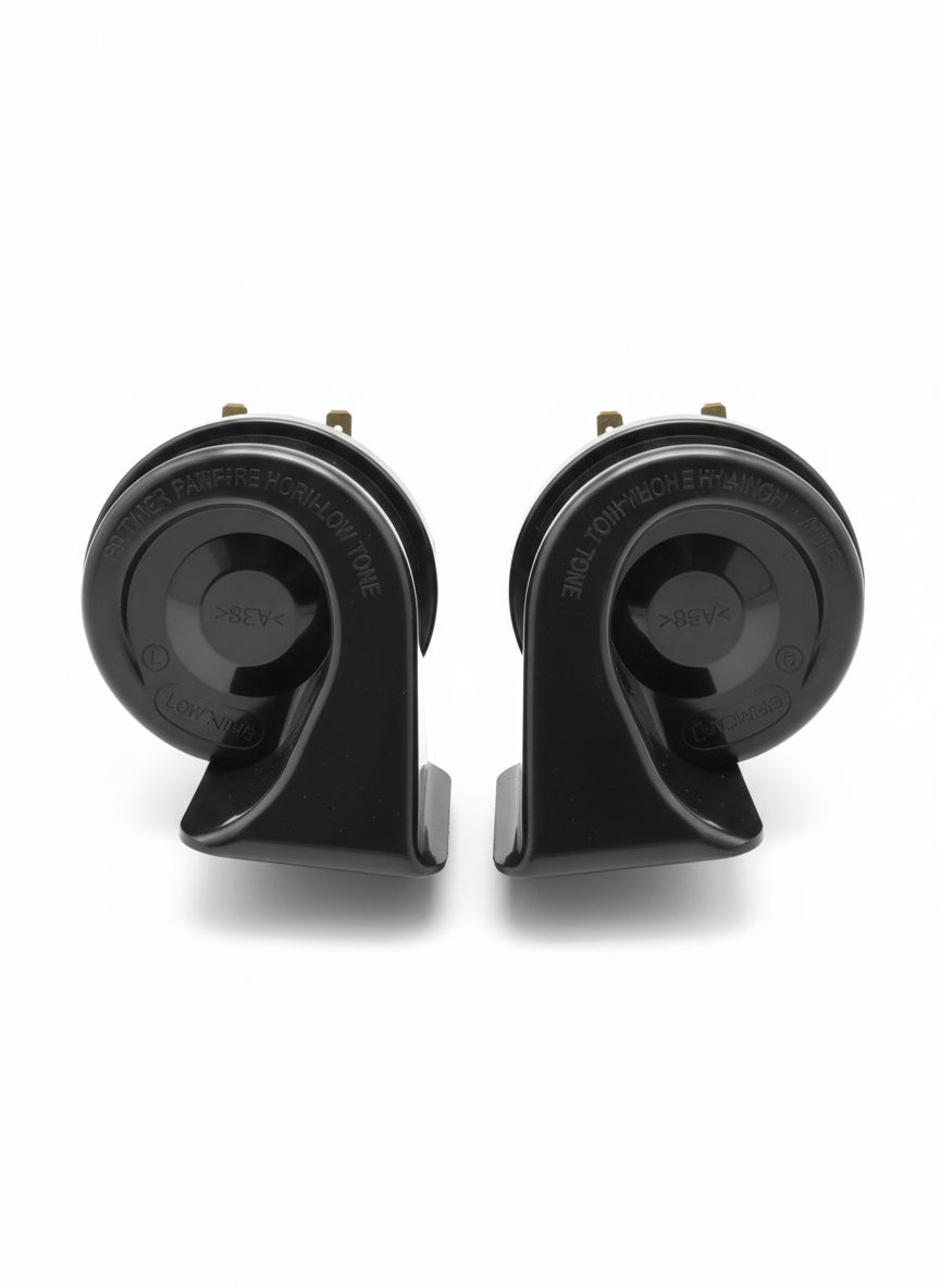 Two black car horns on a wooden surface